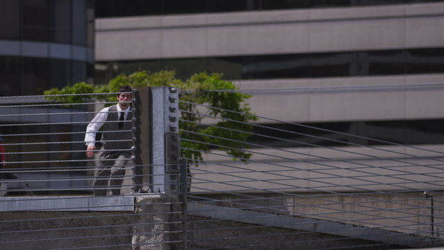 Businessman jumping over parking garage barrier