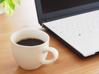 テーブルの上のコーヒーとノートパソコン
