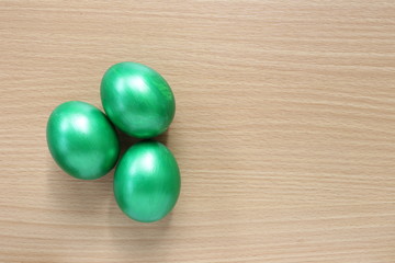 green of easter eggs on wood background.