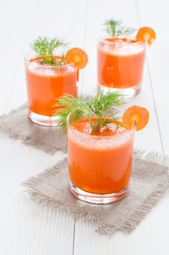 Three glasses of carrot juice, on linen napkin