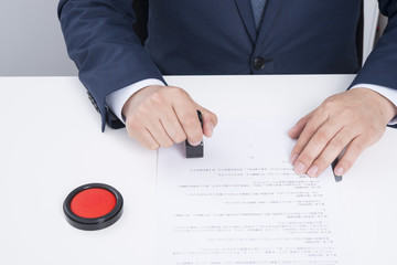 契約書に捺印するビジネスマン