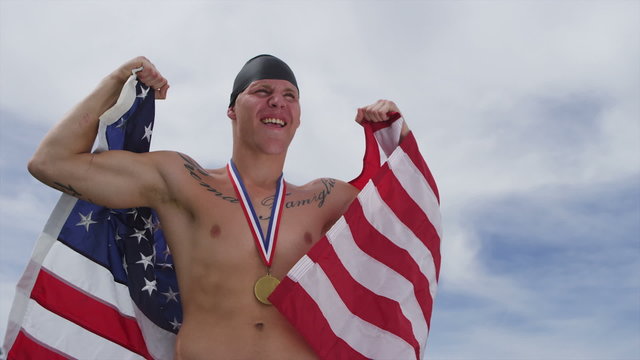 Swimmer celebrating with medal and American flag
