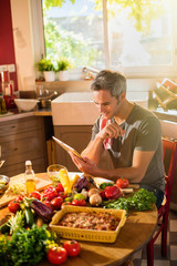 Grey haired man looking at vegetables recipes on a tablet