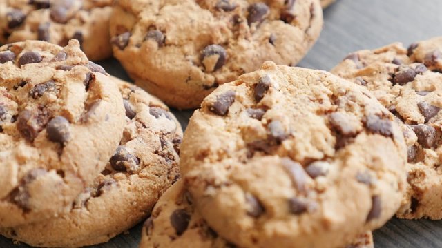 Chocolate chip cake biscuits on the table slow tilt 4K 2160p UltraHD footage - Slow tilting over chocolate cookies on wooden surface 4K 3840X2160 UHD video 