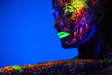 People are colored fluorescent powder. a pair of lovers dancing at a disco.