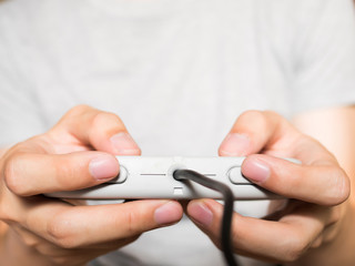 A young man holding game controller playing video games (vintage tone)