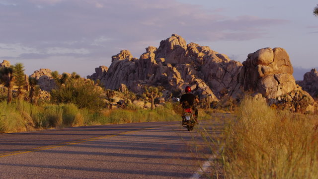 Man riding motorcycle through desert