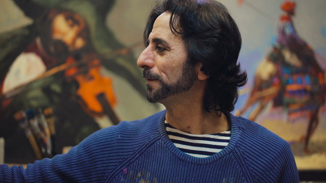Inspiration. Senior painter holding a palette. creates in his studio