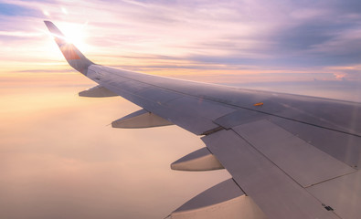 Fototapeta na wymiar Looking through window aircraft wing during flight and look cloud in beautiful