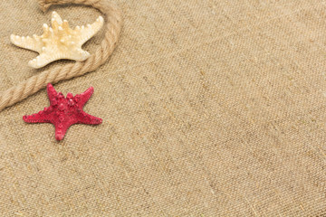 Fototapeta na wymiar starfish and rope lying on a sackcloth