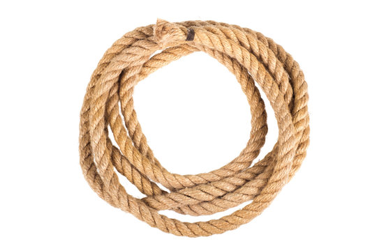 Hemp three strand rope coiled in a circular pattern isolated against a white background.