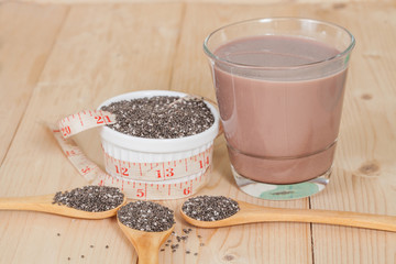 Nutritious chia seeds in bowl and spoon on a wooden
