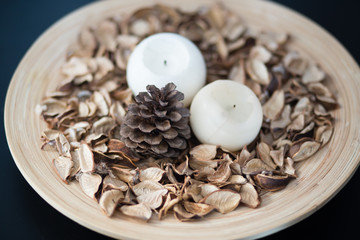 Plate with scented home decor, candles and pinetree cone