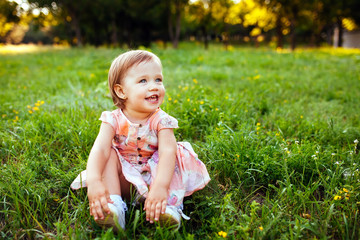 Little girl sitting on the grass.