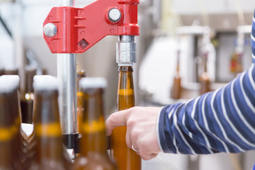 Man using equipment for corking bottles