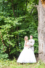 Young wedding couple enjoying romantic moments outside on a summer park