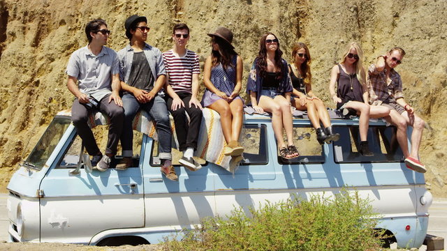 Group portrait of young people sitting together on van