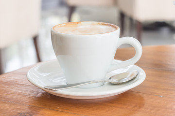 Cup of Art Latte coffee on the wooden desk