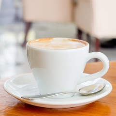 Cup of Art Latte coffee on the wooden desk