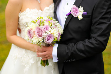 Wedding bouquet with peony, roses, orchids, and green leaves. Tenderness hand made accessory for bride