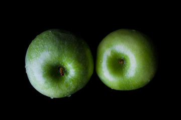 Two green fresh ripe apples on black background directly from above