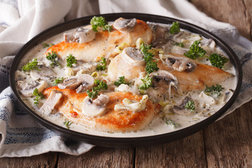 Chicken with mushrooms and leek in a creamy sauce close-up 
