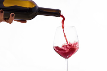 Red wine poured from a bottle into a wine glass