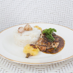 Roasted pepper pork served with rice and pineapple
