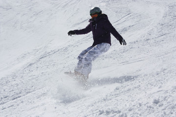 Fototapeta na wymiar Young snowboarder woman sliding downhill and brake sharply.