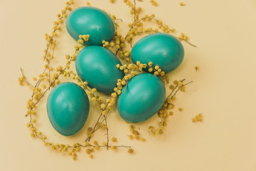 Flat lay stylish set: green hipster colored Easter eggs with marker inscriptions and flowers