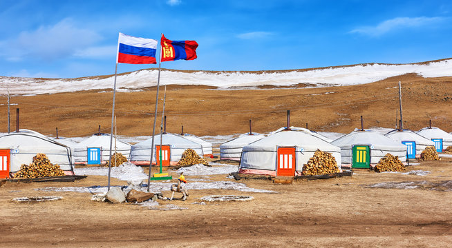 Russian and Mongolian flag next to gers (yurts)