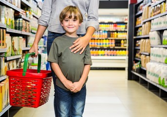 Cute boy doing grocery shopping with mother