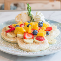Pancakes served with fruits and ice cream