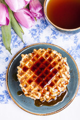 Fresh waffles with maple syrup and coffee
