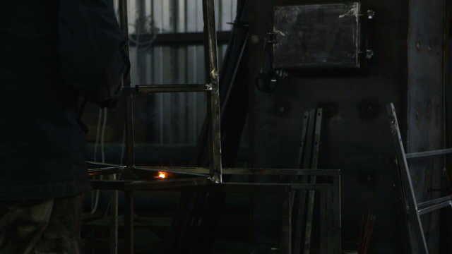 Work at the plant. Electric welder at work. Metal construction.