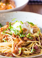 Poached egg on spaghetti with bacon and garlic