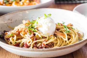 Poached egg on spaghetti with bacon and garlic