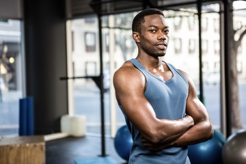 Fototapeta na wymiar Muscular man standing with arms crossed