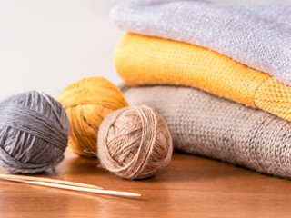 Fototapeta na wymiar yarn, needles and knitwear on wooden table