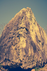 Boulder against blue sky on summer in the day time. Vintage picture style.