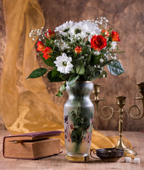 Still life with a bouquet of flowers, a book and a candlestick