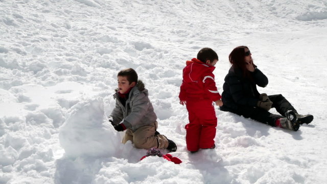 mum and two children playing with snowballs