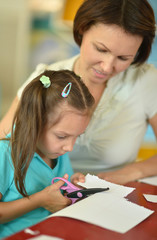 Fototapeta premium Mother with girl cutting together