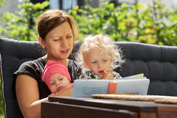 Mother and Daughters Looking at Children´s Book