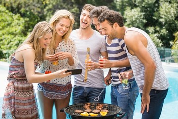 Group of happy friends looking at mobile phone