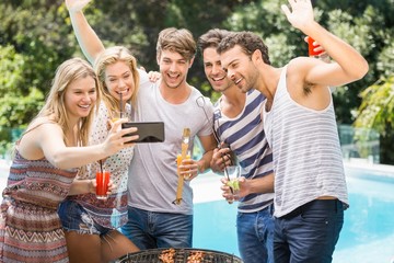 Group of friends taking a selfie near pool