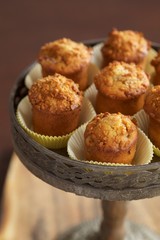 Plum muffins on cake stand on wooden table