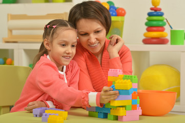 little girl playing with mother