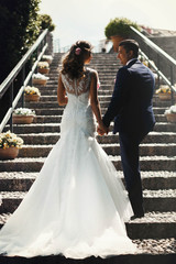 Fototapeta premium Stylish young happy bride to the groom on the background ancient