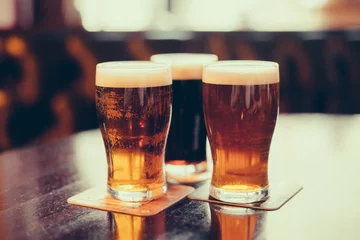 Crédence de cuisine en verre imprimé Bière Verres de bière claire et brune sur fond de pub.